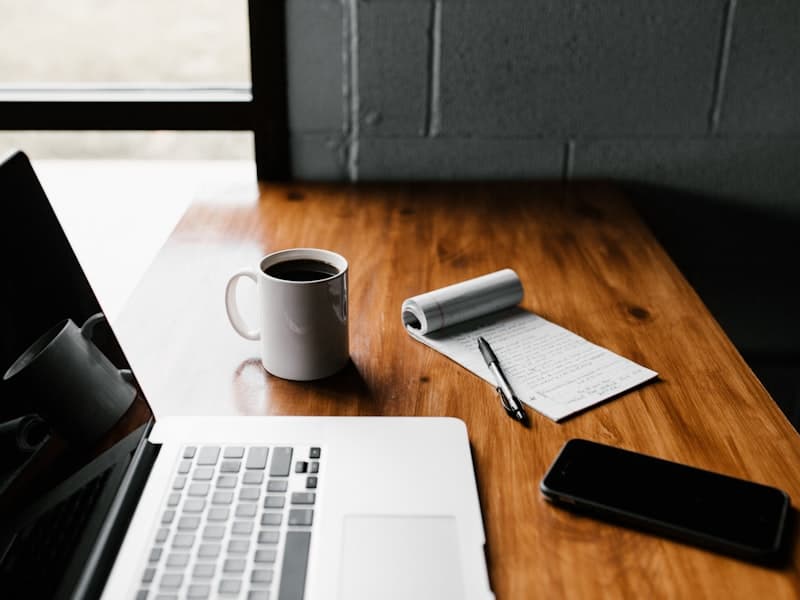 Individual workspace with laptop, coffee, and notepad for focused work